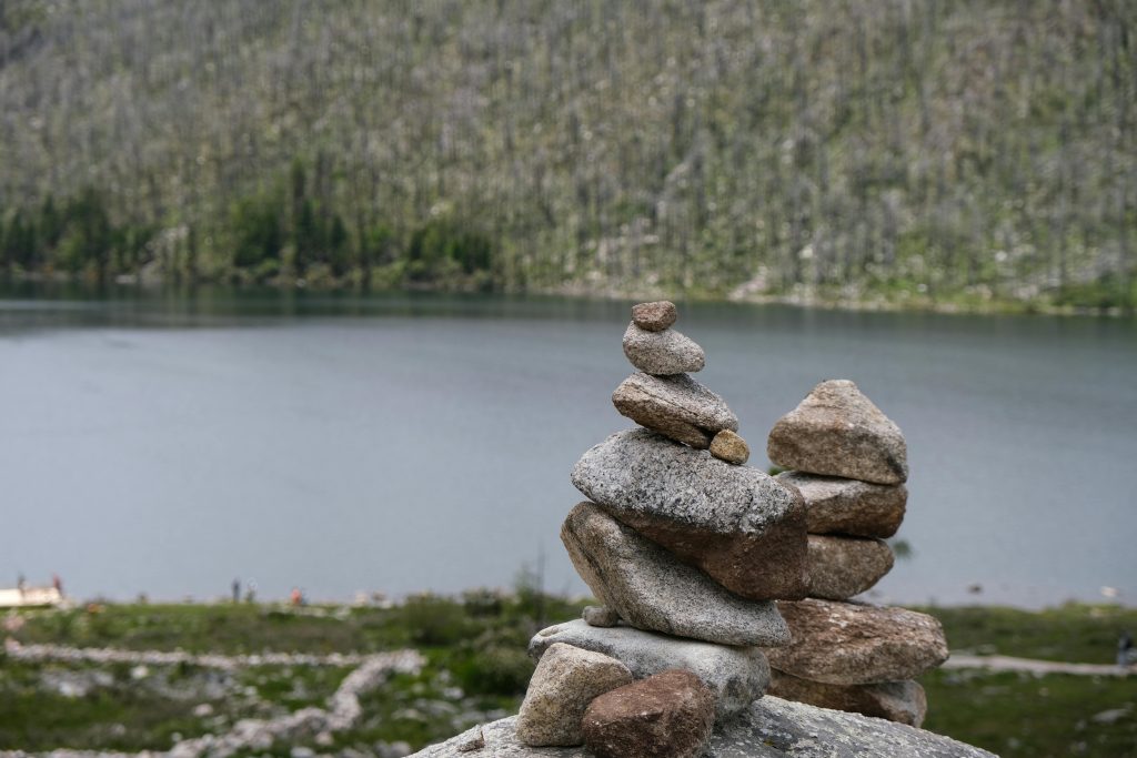 A peaceful stone stack by a calm lake in China, perfect for zen and tranquility themes.